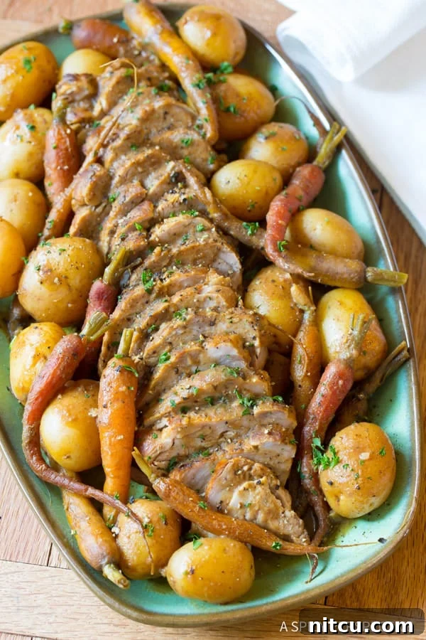 Melt-in-Your-Mouth Slow Cooker Pork Loin and Root Veggies 3 Sliced slow cooker pork tenderloin on a plate with vegetables