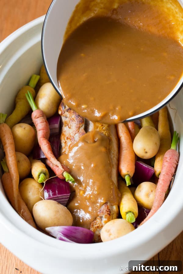 Melt-in-Your-Mouth Slow Cooker Pork Loin and Root Veggies 8 Crock Pot Pork Loin with Vegetables on a platter, covered with rich gravy