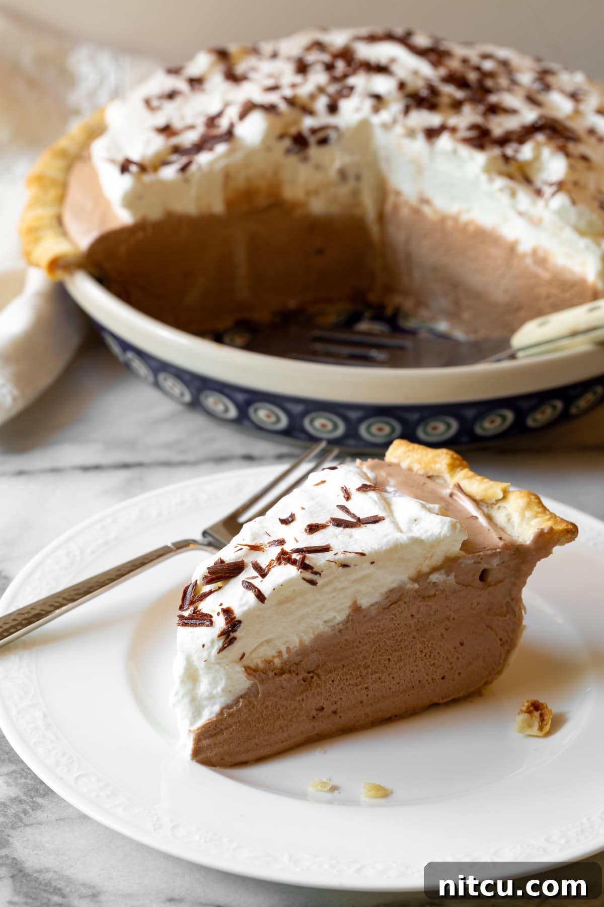 French Silk Pie #ASpicyPerspective #FrenchSilkPie #SilkPie #FrenchSilkPieRecipe #ChocolateSilkPie #Chocolate #Silky #Fluffy #Pie #Dessert A stunning shot of a chocolate pie, showcasing its smooth filling and fluffy whipped topping.