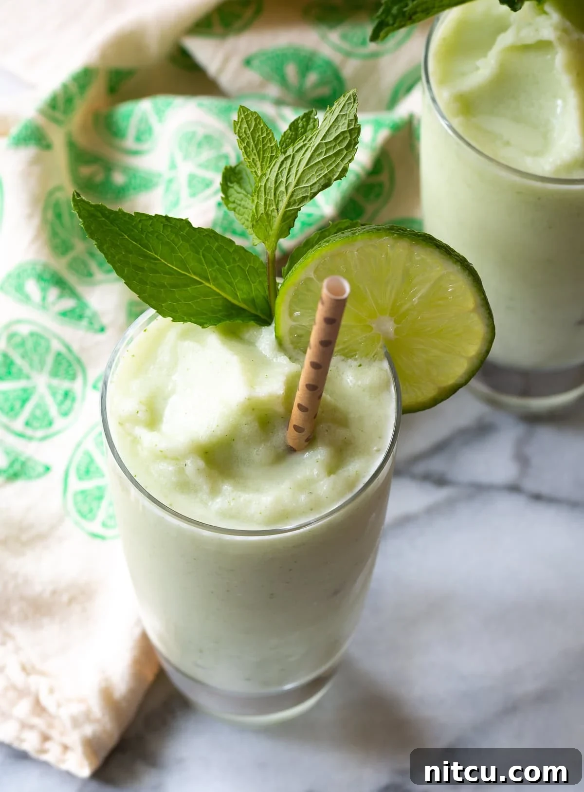 Coconut-Mojito-Recipe Delicious Frozen Coconut Mojito in a glass with mint and lime garnish
