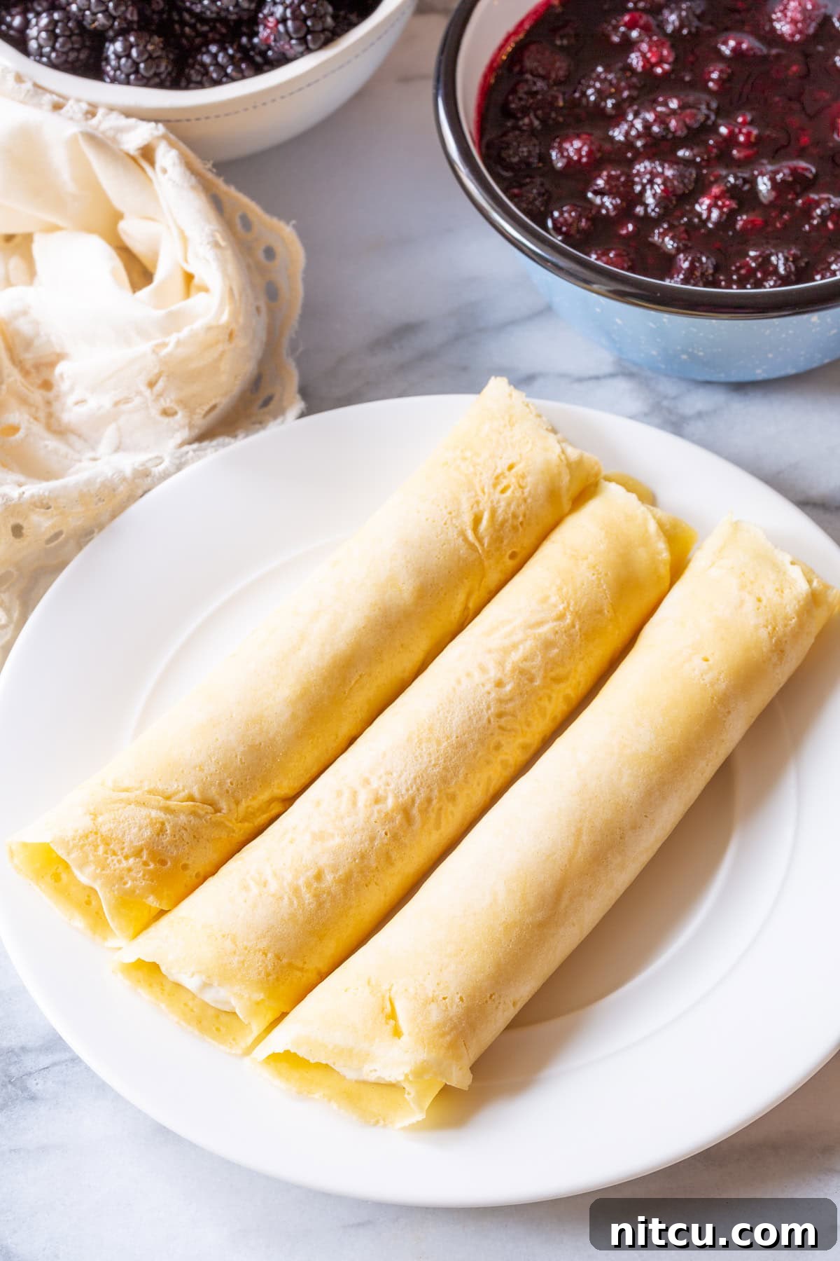 Golden Cheese Blintzes 7 Rolling blintz pancakes around ricotta cream and stacking them neatly on a plate