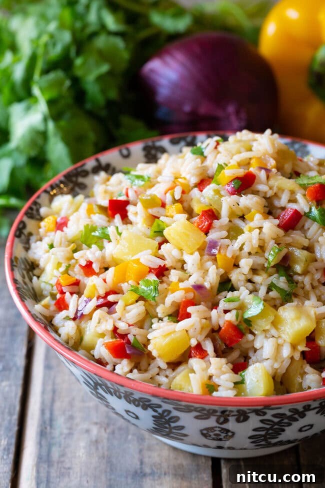 Caribbean Rice #ASpicyPerspective #Rice #Caribbean #CaribbeanRice #CaribbeanRiceRecipe #ConfettiRice #SideDish #Jalapenos #Pineapple #BellPeppers #CoconutMilk Caribbean Rice in bowl.