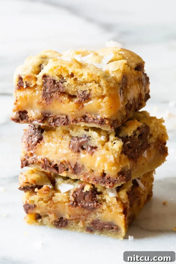 Caramel chocolate chip cookies bars stacked on top of each other.