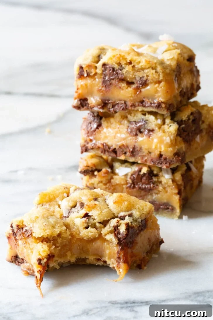 Stack of cookie bars with one in front with a bite taken from it.
