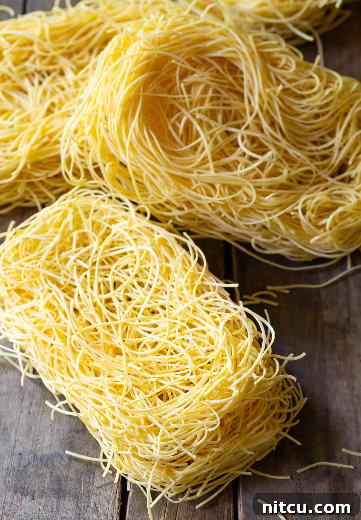 Savory Cantonese Pork Noodles 4 A vibrant pile of uncooked egg noodles, perfectly prepared for making a delicious batch of Lo Mein.
