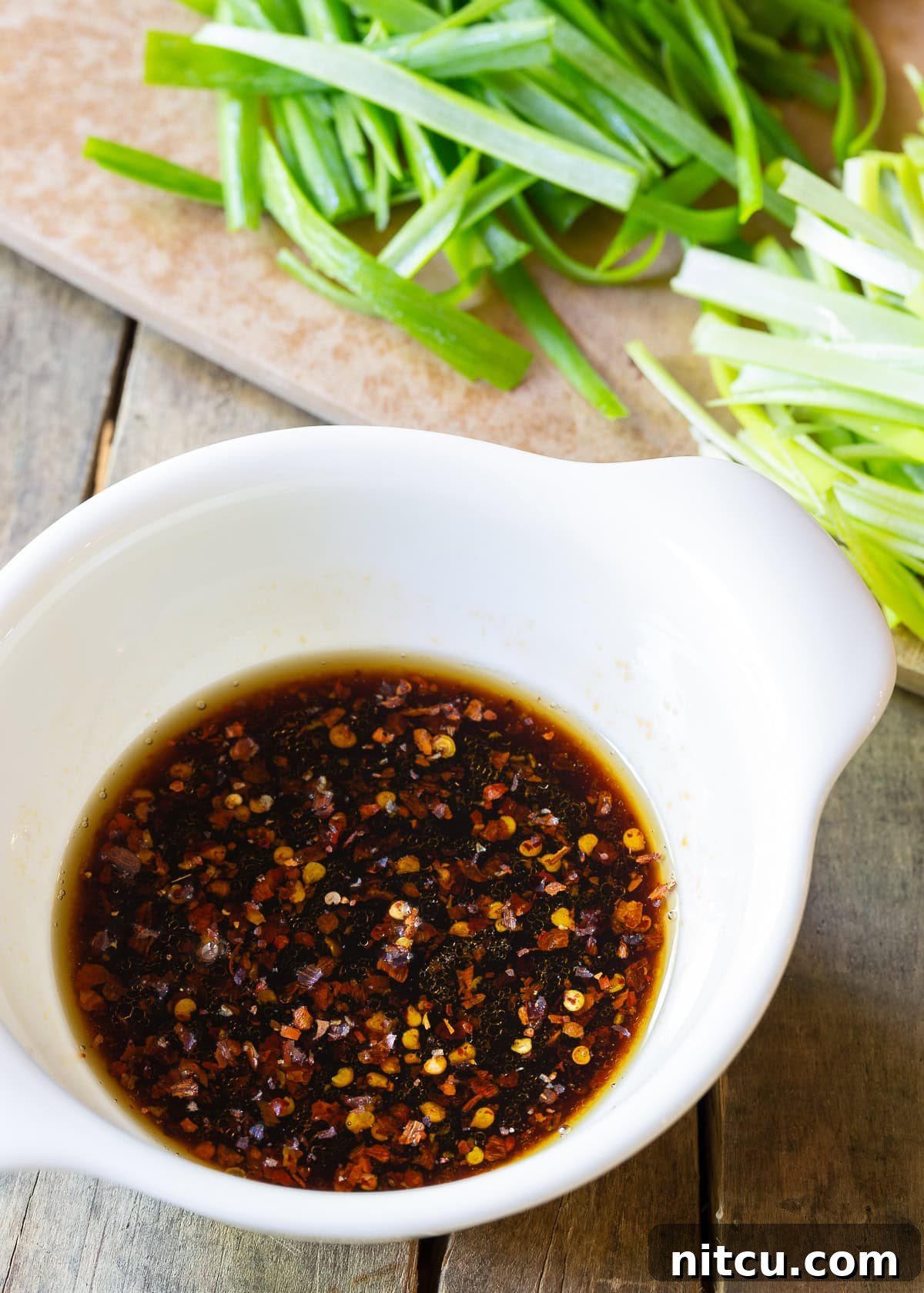 Savory Cantonese Pork Noodles 5 A small white bowl filled with the rich, dark, and flavorful sauce mixture for pork lo mein, ready to be added to the stir-fry.