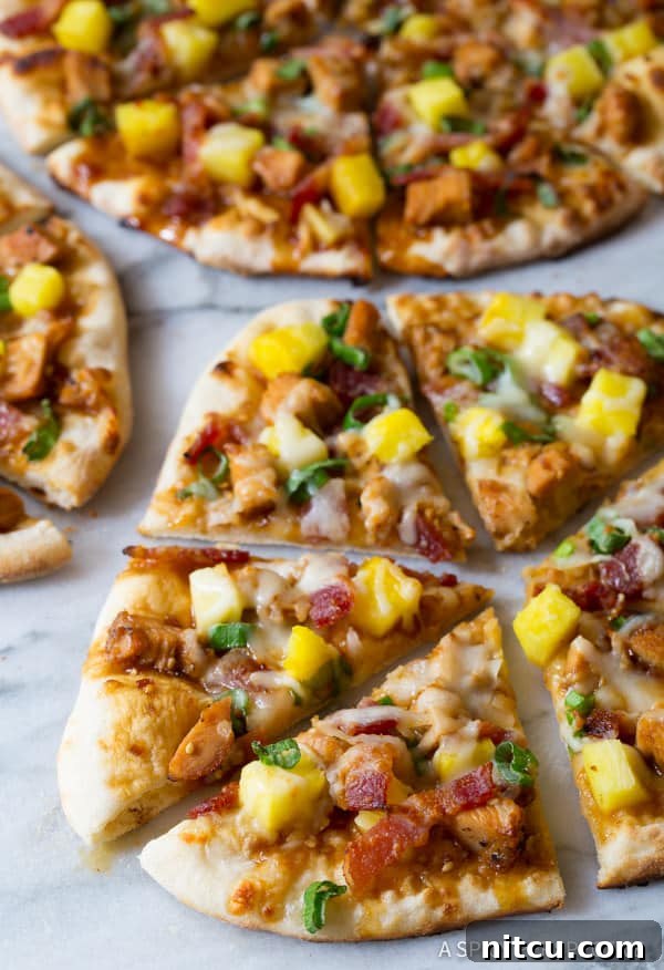Umami Grilled Teriyaki Chicken Pizza 5 Teriyaki Pizza close up of pizza slices with chicken, pineapple, and melted cheese, ready to be eaten.
