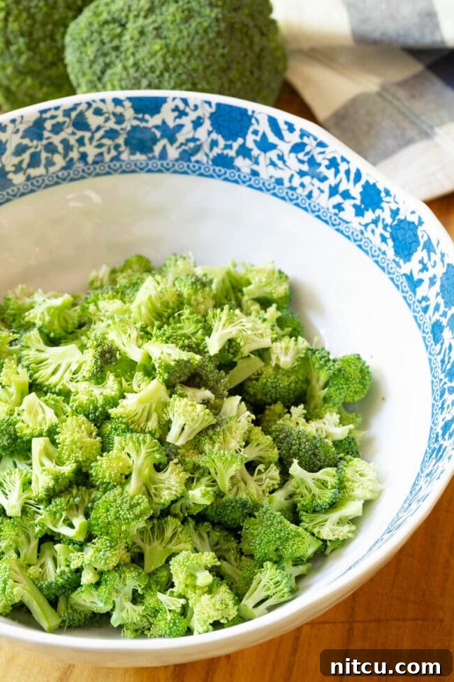 Freshly chopped broccoli florets in a large bowl, ready for salad preparation.