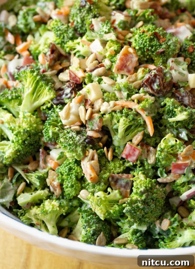 Close-up shot of fresh, chunky broccoli slaw recipe with bacon, showing its vibrant texture and irresistible appeal.