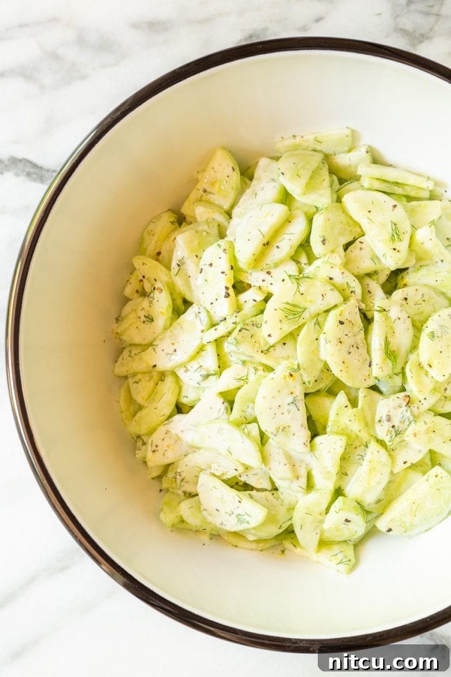 Crisp Cucumber Dill Delight 3 A large bowl of vibrant creamy cucumber dill salad, beautifully presented and ready to be served at a summer potluck or family dinner.