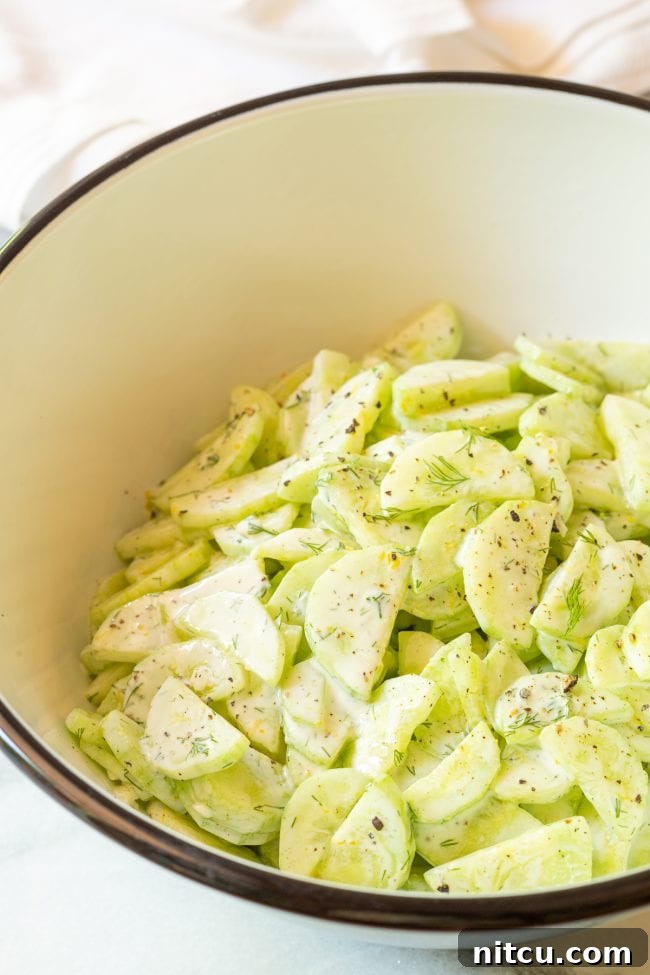 Greek Creamy Cucumber Salad: A healthy and flavorful side dish for any occasion, perfect for sharing. A large serving bowl filled with a beautifully prepared Greek Creamy Cucumber Salad, garnished with fresh dill sprigs, ready to be enjoyed.