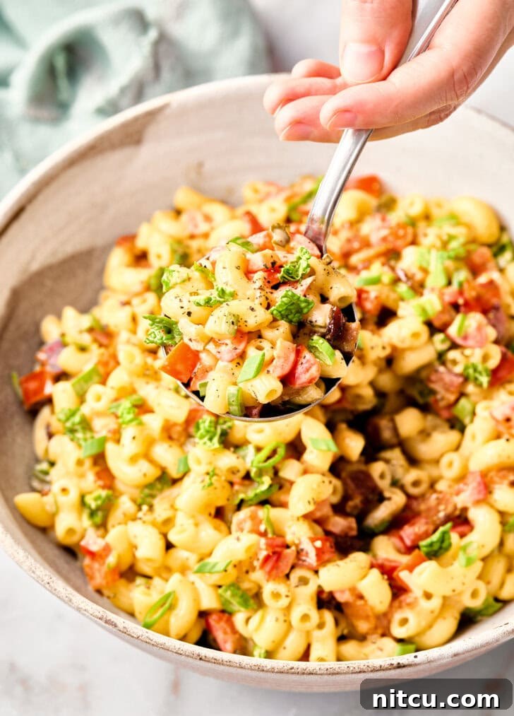 The Best Macaroni Salad with Bacon and Kale Best Macaroni Salad Recipe with spoon lifting salad out of bowl