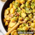 Hot German Potato Salad Recipe in pan with wooden spoon