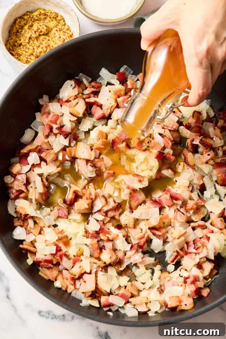 Tangy Warm German Potato Salad 6 Pouring broth and cooking onions and bacon for warm potato salad