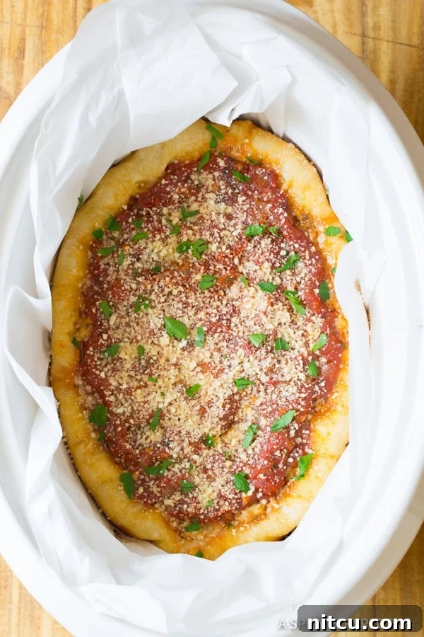 A top-down view of the slow cooker pizza after it has finished cooking, revealing a beautifully golden crust and melted toppings.