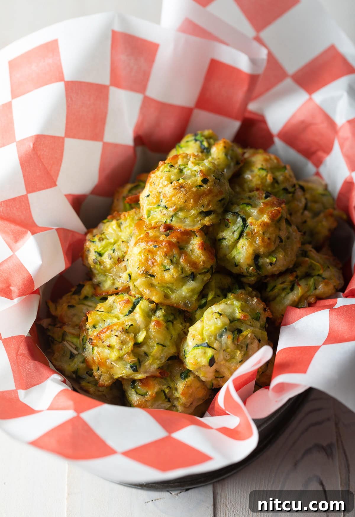 Crispy Zucchini Bites 2 Crispy, golden baked zucchini tots served in a rustic basket, ready to be enjoyed.