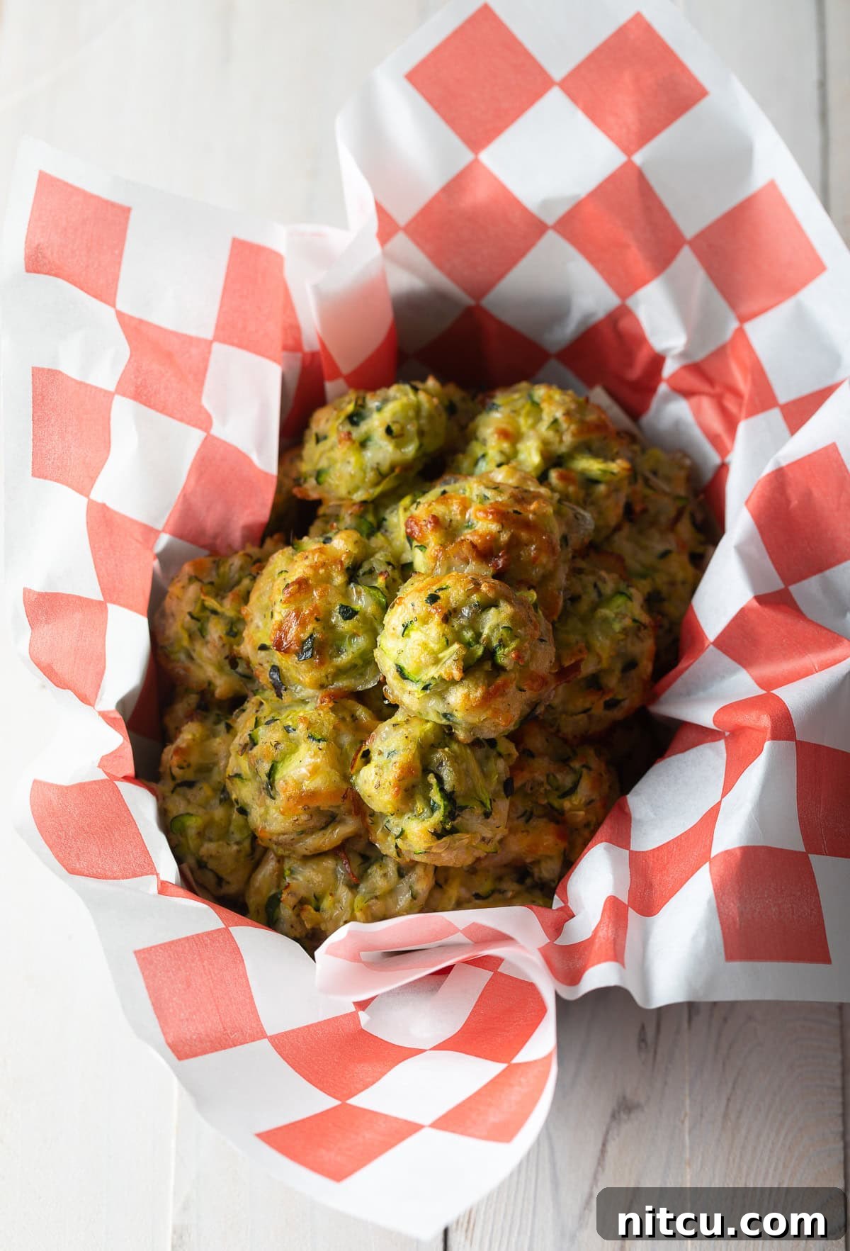 Crispy Zucchini Bites 8 A generous basket overflowing with perfectly baked zucchini tots, highlighting their inviting golden-brown hue.