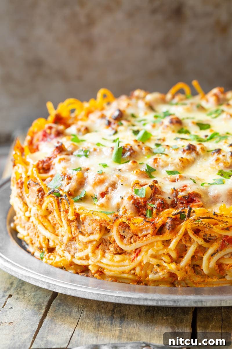 Close up of baked spaghetti pie with a golden, cheesy top.