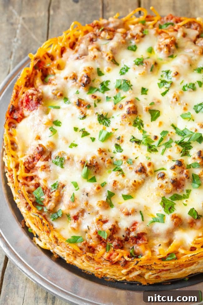 Spaghetti pie served with a side of green salad.