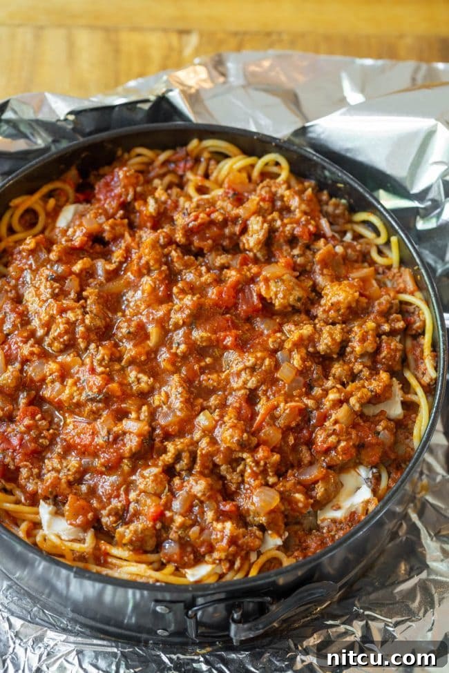 Spaghetti mixture pressed into a springform pan.