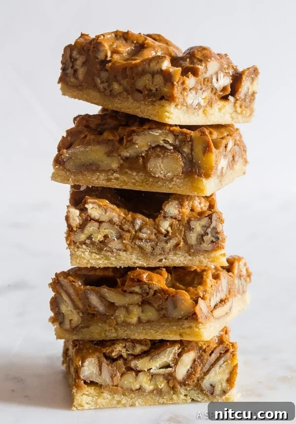 Pecan-Pie-Bar-Recipe Pecan Pie bars stacked on top of each other, showcasing their inviting layers.