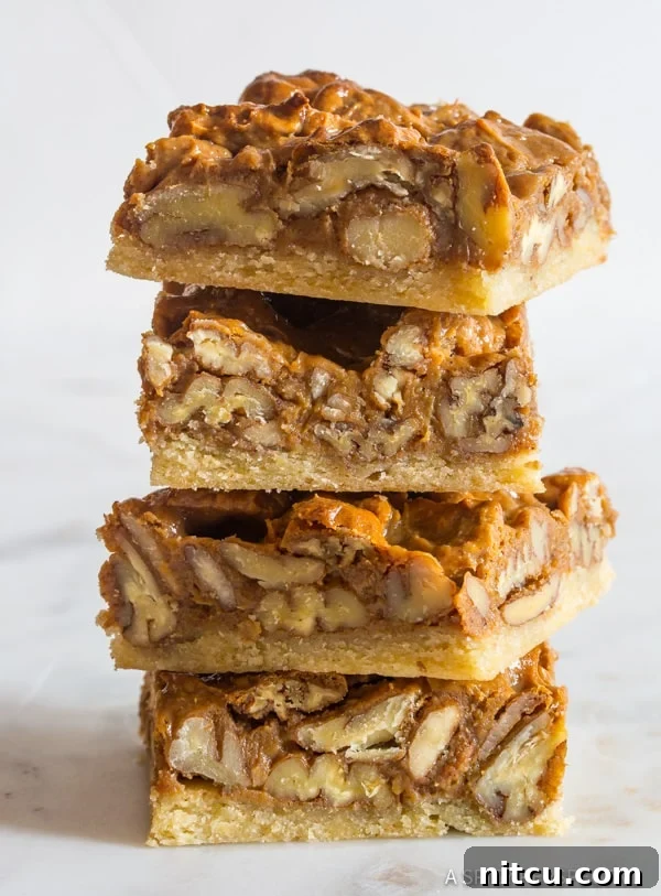 Holiday-Dessert-Bar-Idea Pecan pie bars stacked to reveal their beautiful layers and textures, a perfect holiday dessert.