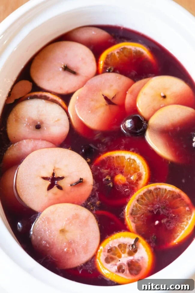 Spiced Holiday Wassail 2 Crockpot Wine Wassail Recipe with fruit floating in the crock