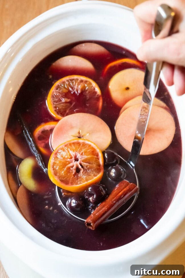 Spiced Holiday Wassail 5 Mulled Wine (Hot Wassail Recipe) in a large crock with fruit floating on the top