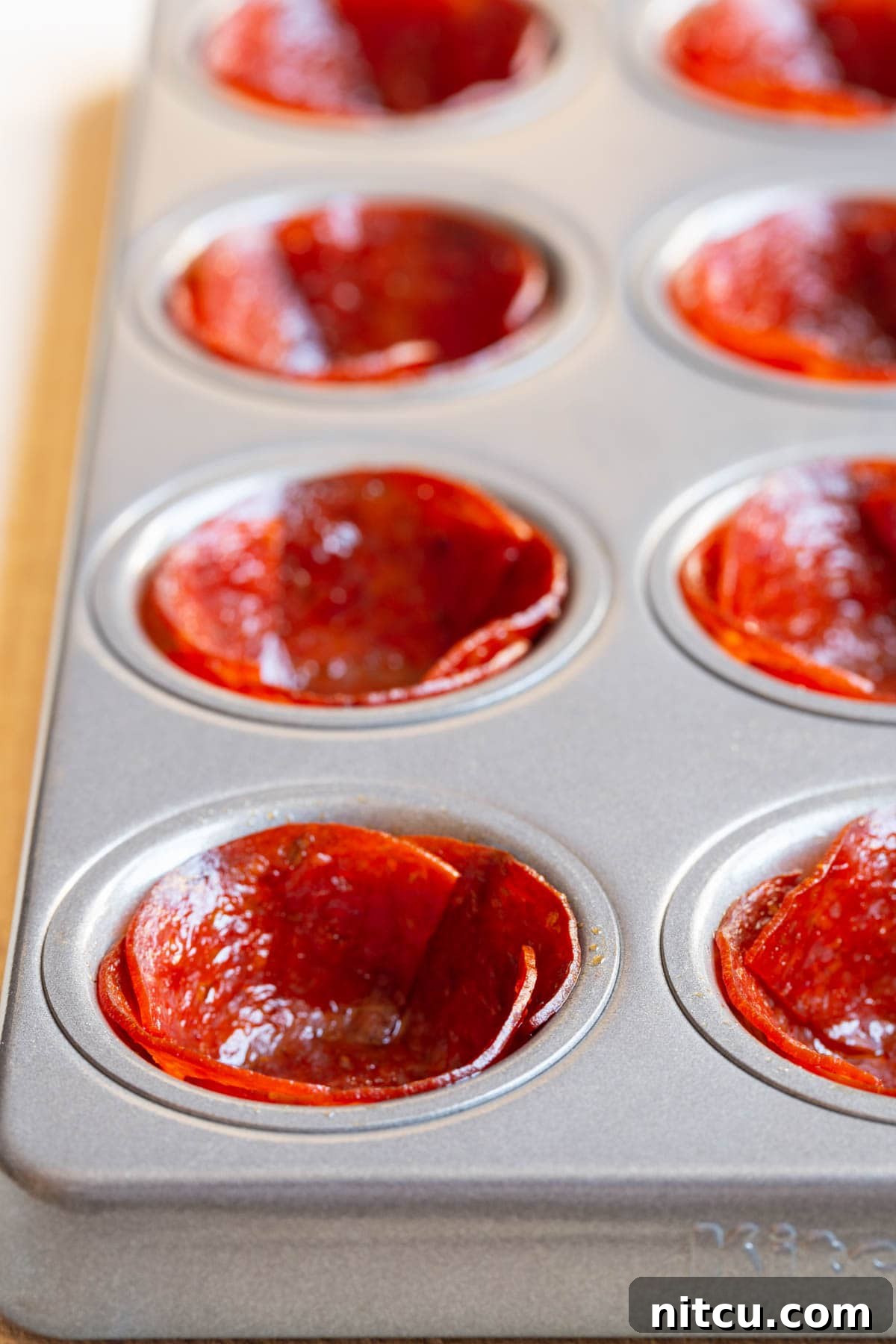 Savory Pepperoni Crisps 4 A mini muffin tin filled with perfectly baked, crispy pepperoni shells, ready for their delicious fillings.