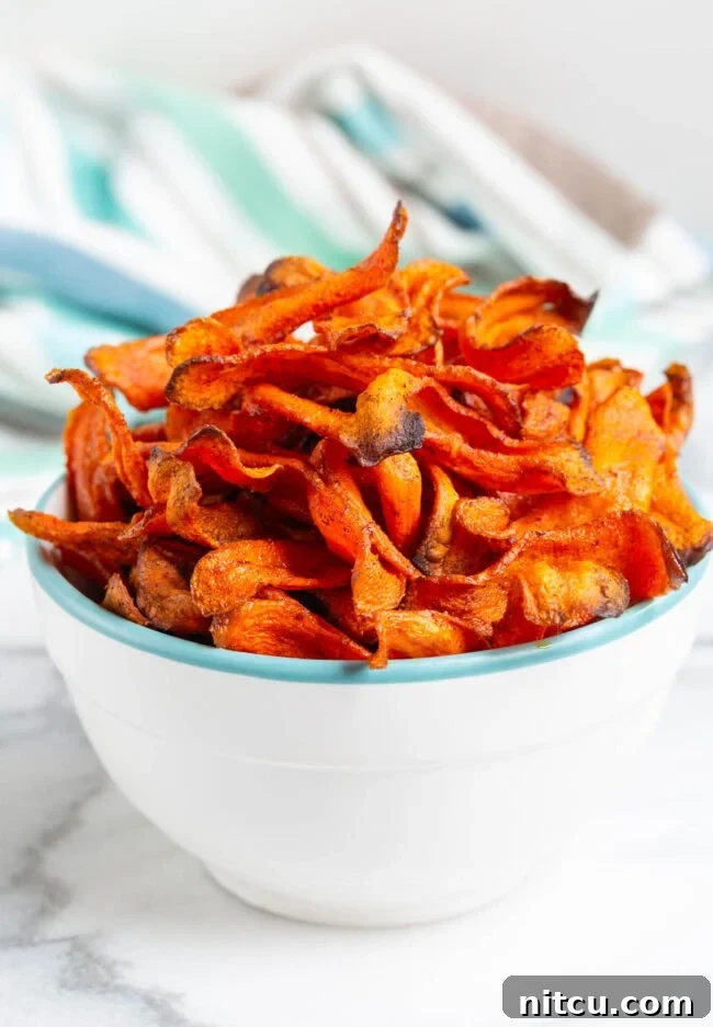 Healthy Baked Carrot Chips Recipe Crispy carrot chips piled high in a bowl, a perfect healthy snack.