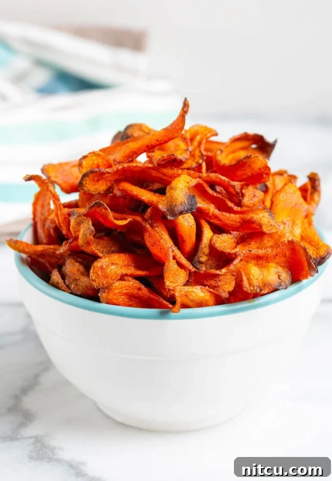 Healthy Carrot Chips A bowl of delicious and healthy baked carrot chips, ready to be enjoyed as a snack.