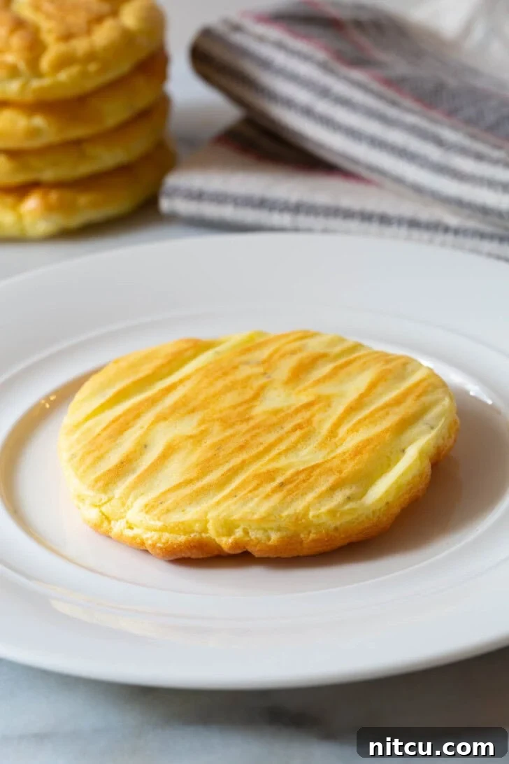 No Carb Bread #LowCarb #GlutenFree #GrainFree #Keto #CloudBread #KetoCloudBread #NoCarbBread A single piece of golden-brown cloud bread served on a large white plate, ready to be enjoyed.