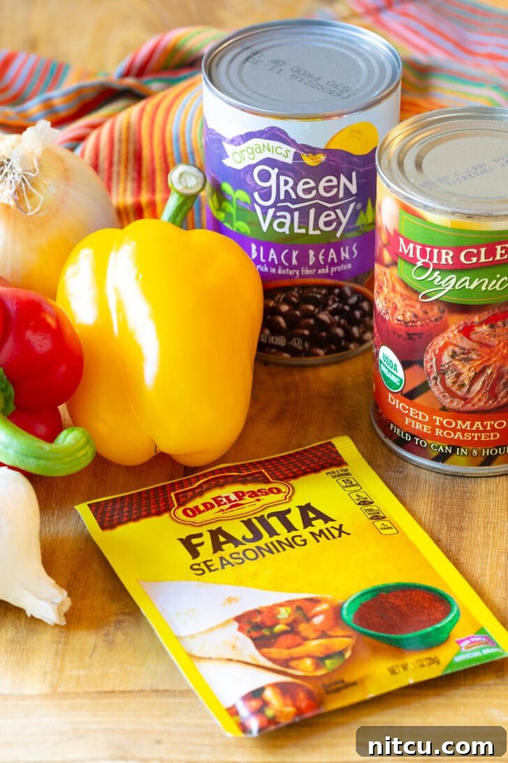 Fajita Soup Ingredients Ingredients for Mexican Chicken Soup laid out on a wooden cutting board: A packet of fajita seasoning mix, vibrant yellow and red bell peppers, a can of diced tomatoes, a can of black beans, and a bulb of garlic.