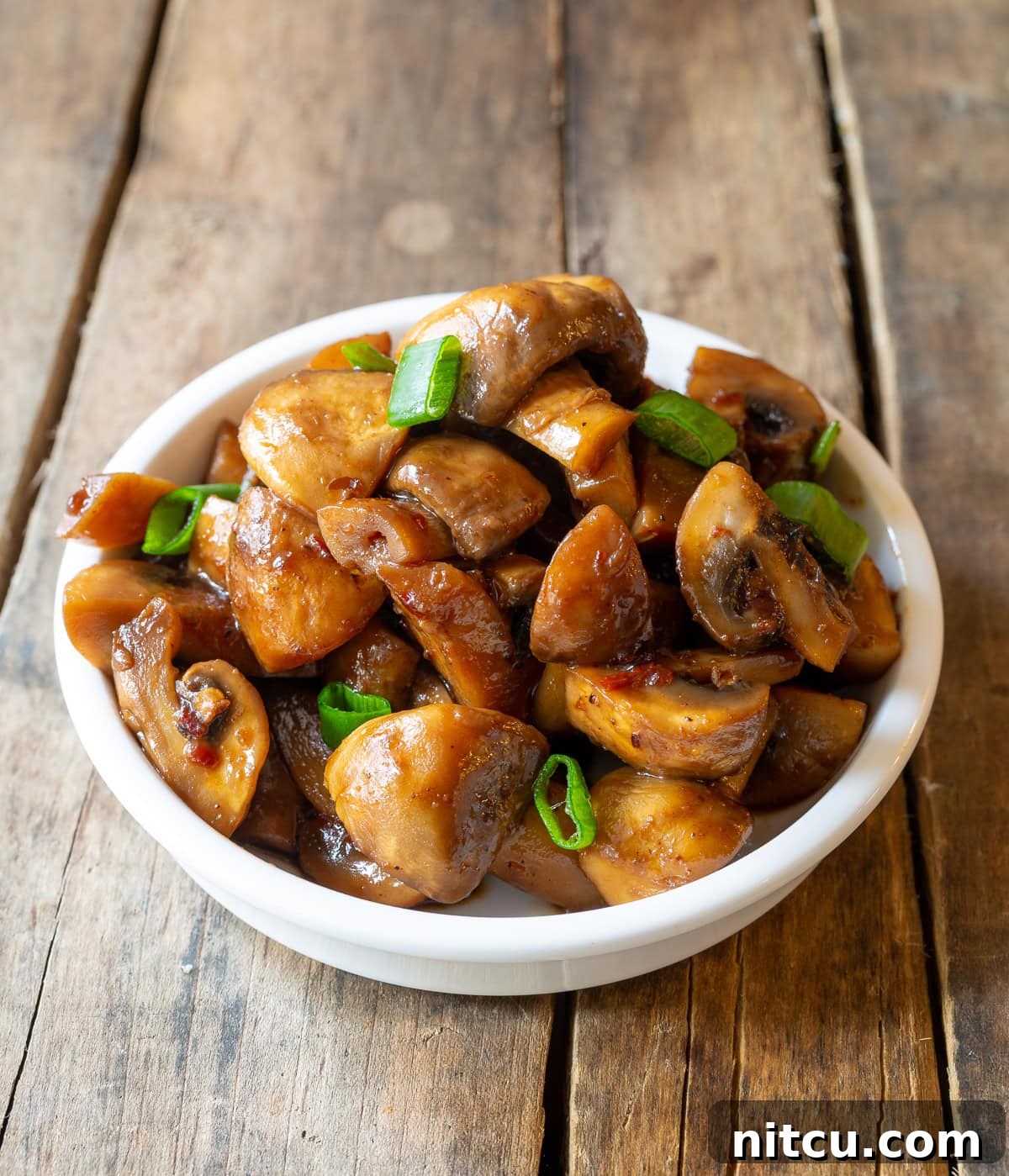 Asian Stir Fried Mushrooms Recipe #ASpicyPerspective #Mushrooms #StirFry #MushroomStirFry #AsianMushroom #Asian #SideDish #Vegetarian #Healthy #LowCarb #LowFat White bowl full with Chinese mushroom Recipe