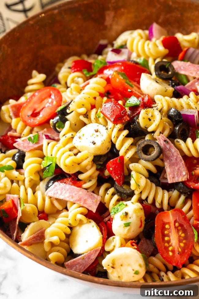 Overhead view of Italian pasta salad in a large serving bowl, showcasing its vibrant colors and rich ingredients.