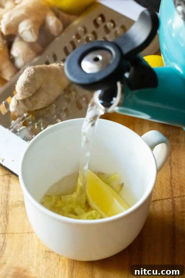 Sunshine Ginger Elixir 7 Steaming hot water being poured over the ginger and lemon in a mug, beginning the brewing process.