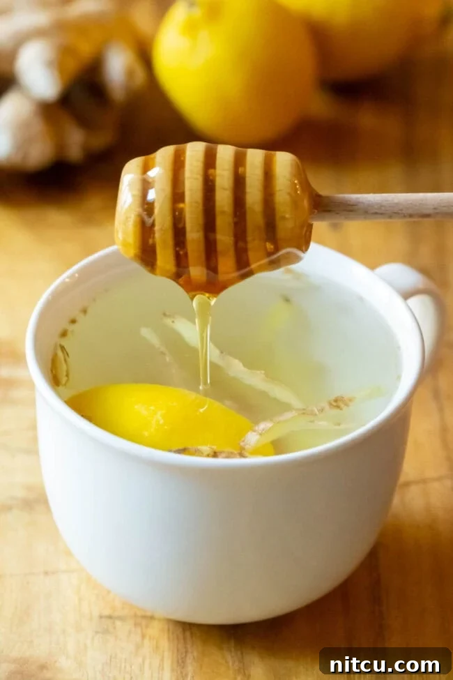 Sunshine Ginger Elixir 8 A drizzle of golden honey being added to the freshly brewed lemon ginger tea.
