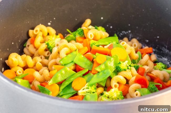 Light & Vibrant Primavera Pasta 6 A large pot filled with drained pasta and blanched vegetables, ready for the sauce.