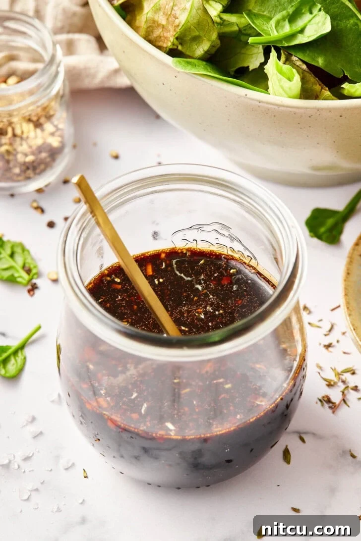 Elevate Your Salad with Homemade Balsamic Vinaigrette 2 Balsamic Dressing Recipe - Homemade balsamic salad dressing in jar with spoon.