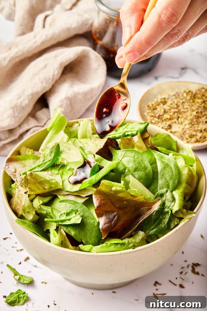 Elevate Your Salad with Homemade Balsamic Vinaigrette 11 Homemade salad dressing with balsamic vinegar poured over greens.