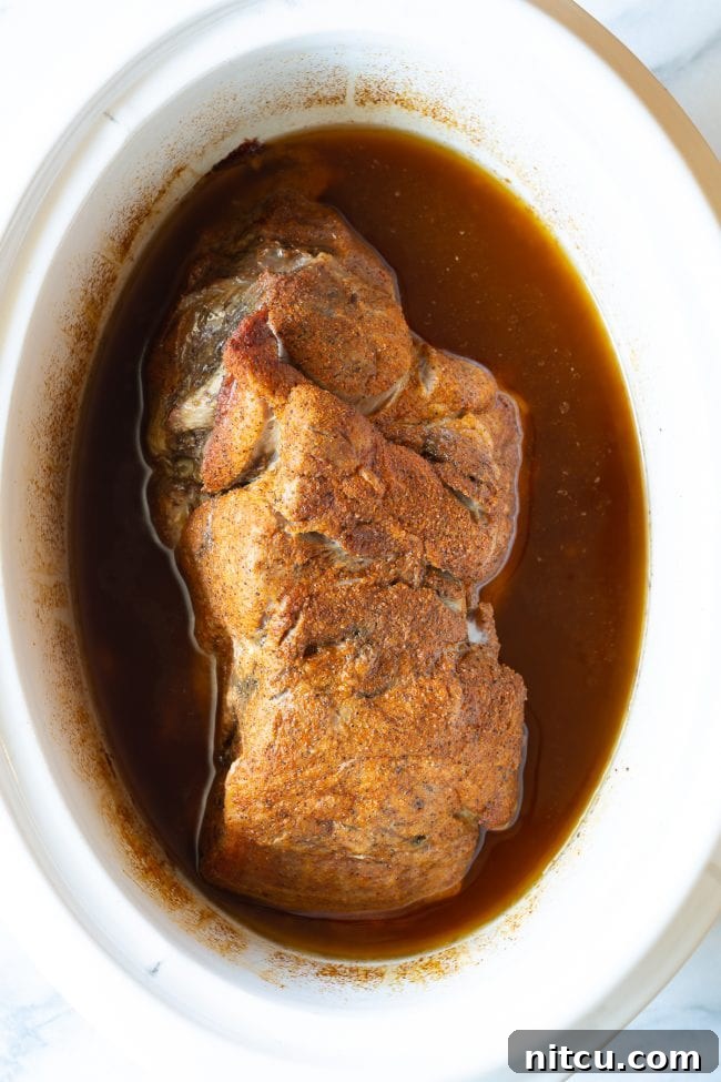 Smoky Perfection: Crockpot Pulled Pork 9 Cooked pork in a crock pot.