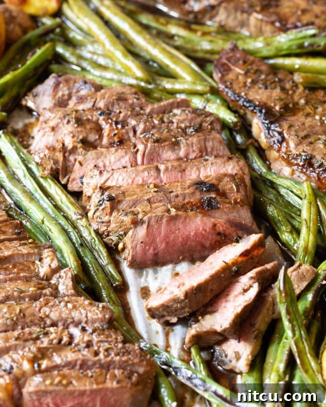 An up-close view of a single slice of steak, showcasing its juicy, pink medium-rare interior texture.