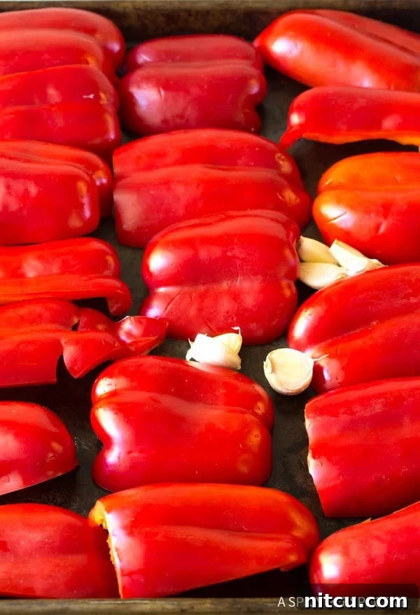 Fire-Roasted Red Pepper Coulis 4 Red peppers and garlic cloves on a baking sheet.