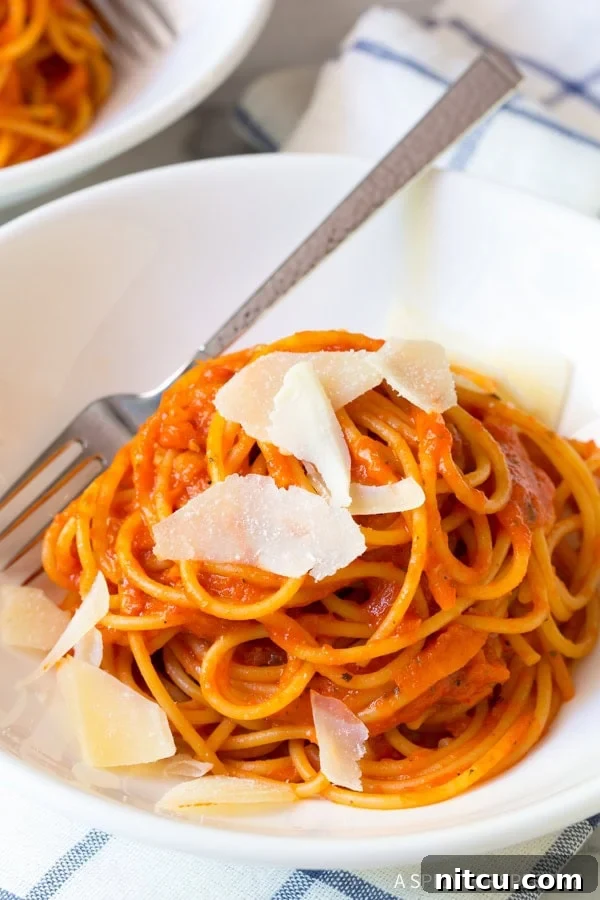 Fire-Roasted Red Pepper Coulis 9 Roasted red pepper pasta with shaved parmesan on top.
