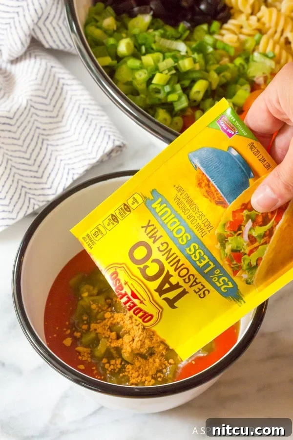 Fiesta Chicken Taco Pasta Salad 10 Combining ingredients for Chicken Taco Pasta Salad