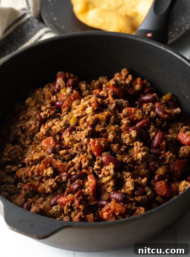 Authentic Navajo Fry Bread 12 Close-up of savory Navajo Taco meat, rich with ground beef, beans, and spices, simmering in a skillet, ready to be served.
