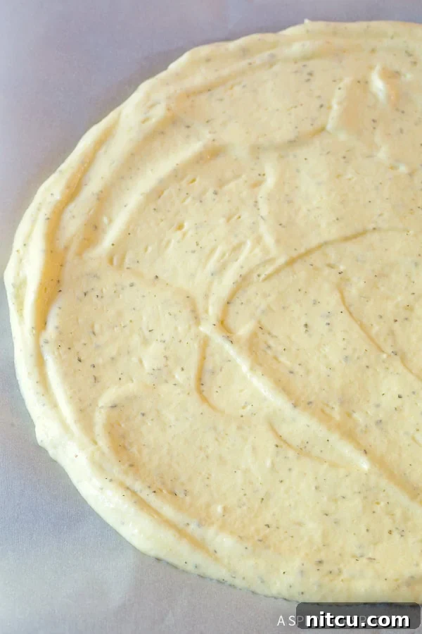 Light & Low Carb Cloud Pizza 7 Cloud bread dough spread into a circle on a baking sheet.