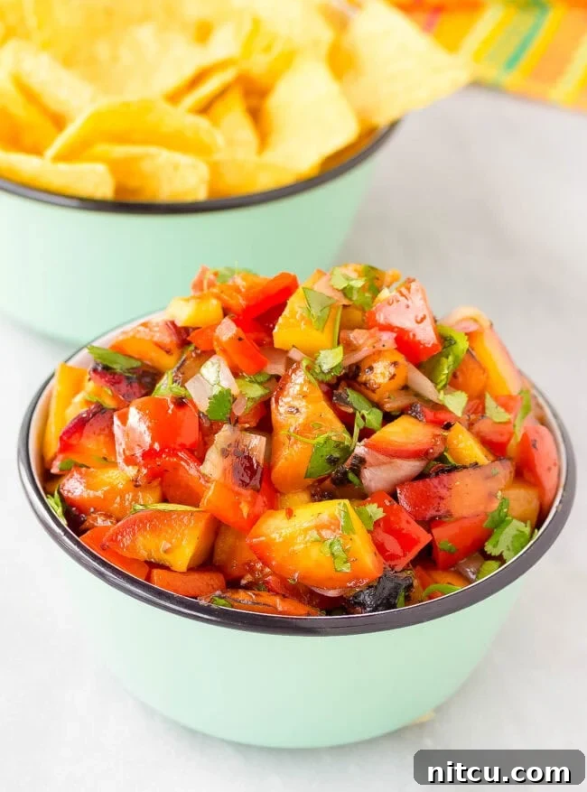 Closeup of grilled peach salsa in a serving bowl, showcasing its texture and deliciousness.