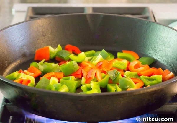 Authentic Croatian Chicken Dinner 5 Vibrantly chopped bell peppers sizzling and charring in a hot cast iron skillet.