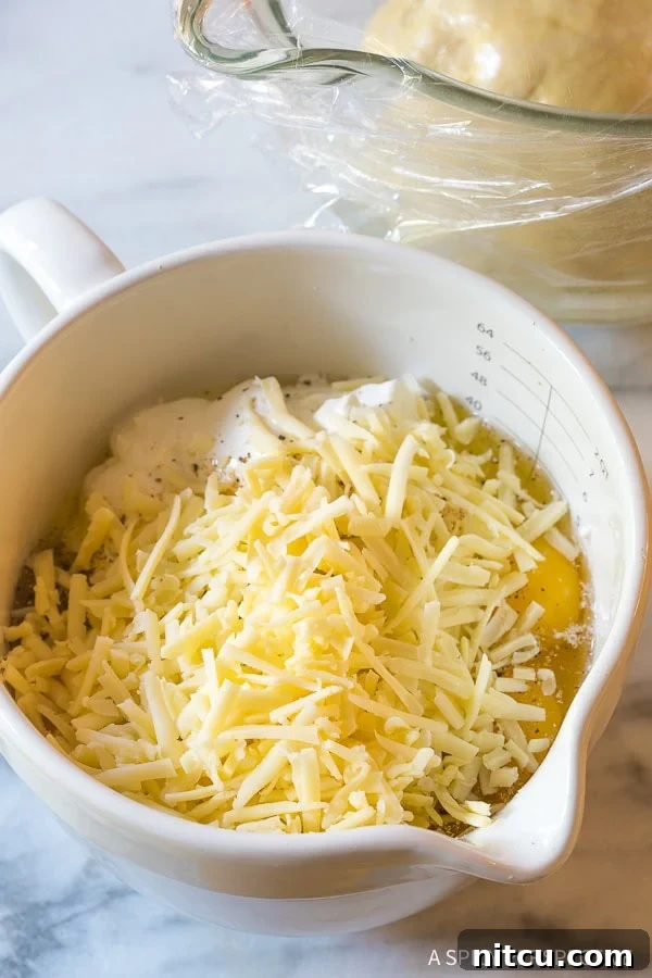 Cheese added to the mixture in the mixing bowl. 